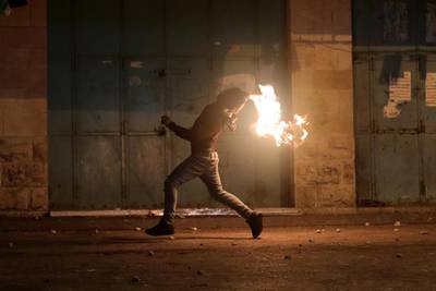 Palestinians throw molotov cocktail during clashes with Israeli security forces in the wake of a protest against US President Donald J. Trump's Middle East peace plan to solve the conflict between Palestinians and Israel, near the West Bank City of Hebron.  EPA