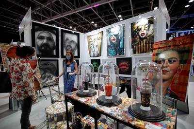 A visitor inspects artworks at the booth of Gallery 27 Dubai. EPA