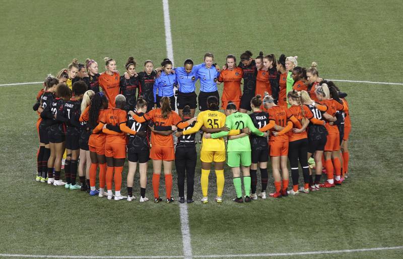 Portland Thorns and Houston Dash players, along with referees, gather at midfield, in demonstration of solidarity with two former NWSL players who came forward with allegations of sexual harassment and misconduct against a prominent coach, during the sixth minute of an NWSL soccer match in Portland, Ore. , Wednesday, Oct.  6, 2021.  (AP Photo / Steve Dipaola)