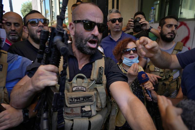 Judge Ghada Aoun is surrounded by security personnel as she leaves the central bank. AP