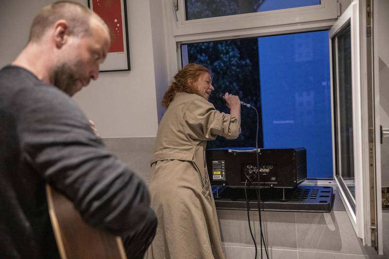 Actor Marleen Lohse sings from home prior to a movie projection on the backyard firewall of residential building in Berlin. Getty Images