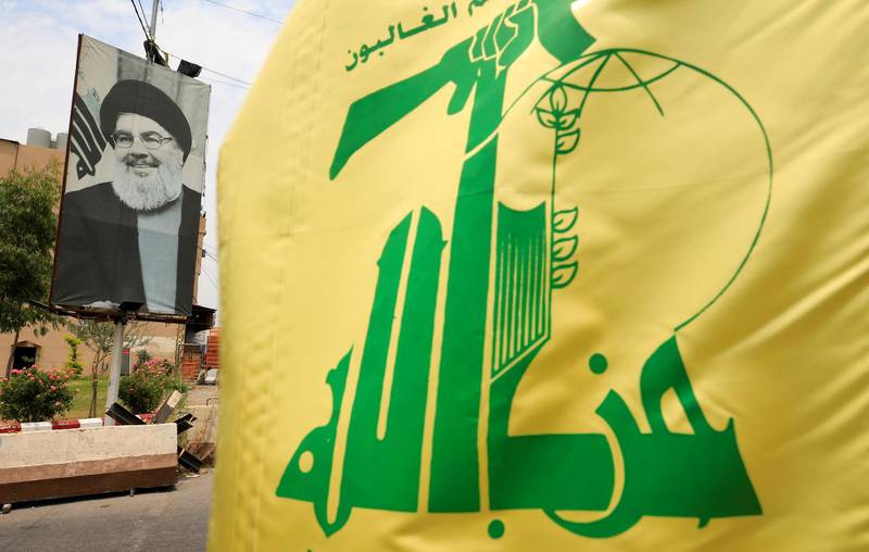 FILE PHOTO: A Hezbollah flag and a poster depicting Lebanon's Hezbollah leader Sayyed Hassan Nasrallah are pictured along a street, near Sidon, Lebanon July 7, 2020. REUTERS/Ali Hashisho/File Photo