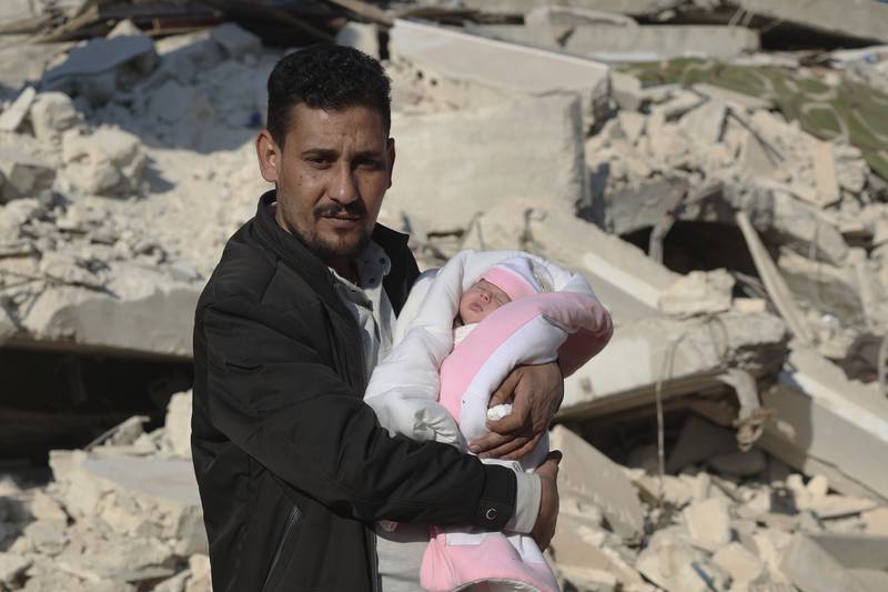 Khalil Al Sawadi holds his niece, Afraa. The car salesman says he will take care of her like one of his own children. AP