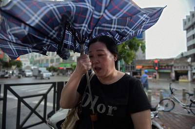A woman battles battles strong winds in China's Guangdong province. AFP