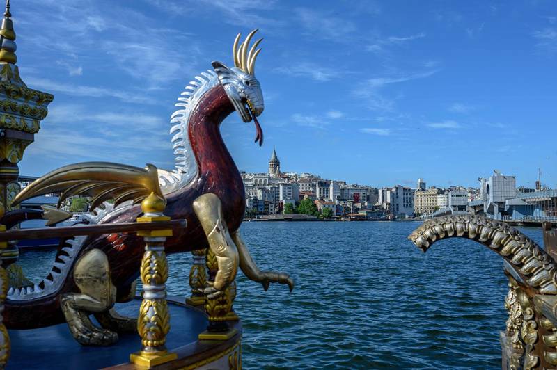 A dragon sculpture decorates an empty fish sandwich boat with the Galata Tower in the background in Istanbul, Turkey. AFP