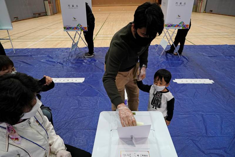 Voters wearing masks in an effort to prevent the spread of the coronavirus disease cast a ballot at a polling station. Reuters