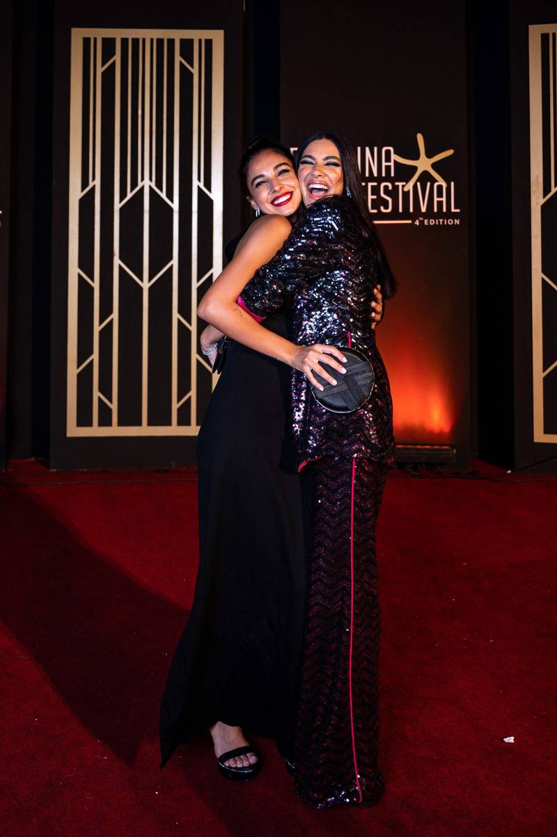 Egyptian actresses Salma Abu Deif and Huda El Mufti hug as they walk the red carpet for the screening of 'The Furnace', on the second day of the 2020 El Gouna Film Festival. AFP