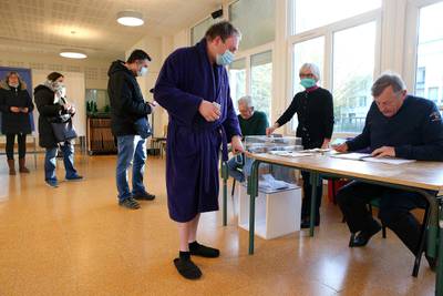 A voter wearing a robe and slippers arrives to cast his ballot at a polling station in Reims, north-eastern France. AFP