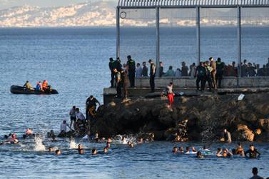 Spanish Guardia Civil officers try to stop people swimming from Morocco to Ceuta, a Spanish enclave with which it shares a border, on Monday. AP