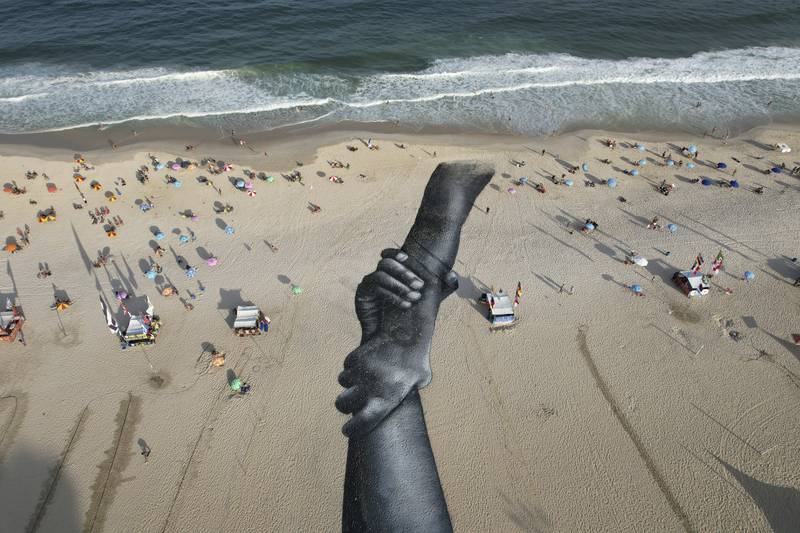 A land-art fresco made from biodegradable paint by French-Swiss artist Saype, covers Copacabana Beach in Rio de Janeiro, Brazil, as part of the artist's worldwide 'Beyond Walls' project. AP