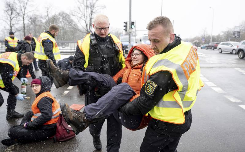 A climate protester is carried away by police after holding up traffic in Leipzig, Germany. AP