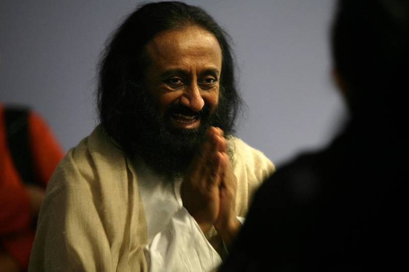 Indian spiritual leader, humanitarian and teacher, Sri Sri Ravi Shankar greets a member of the audience gathered in Milnerton, Cape Town, on August 28, 2012. Sri Sri Ravi Shankar is the founder the Art of Living Foundation  AFP PHOTO / MARK WESSELS (Photo by Mark Wessels / AFP)