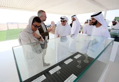 Sheikh Majid bin Saud Al Mualla and Noura Al Kaabi, Minister of Culture and Youth, are shown artefacts that were discovered at the site.