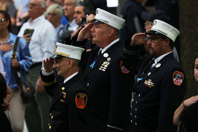 Firefighters salute during the singing of the National Anthem at the annual 9/11 Commemoration Ceremony at the National 9/11 Memorial and Museum in New York City. Getty Images