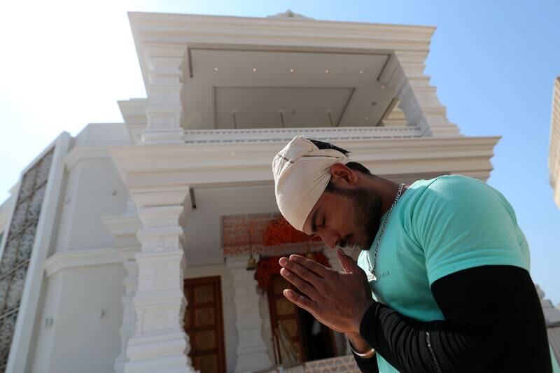 A man prays at the entrance of the temple.