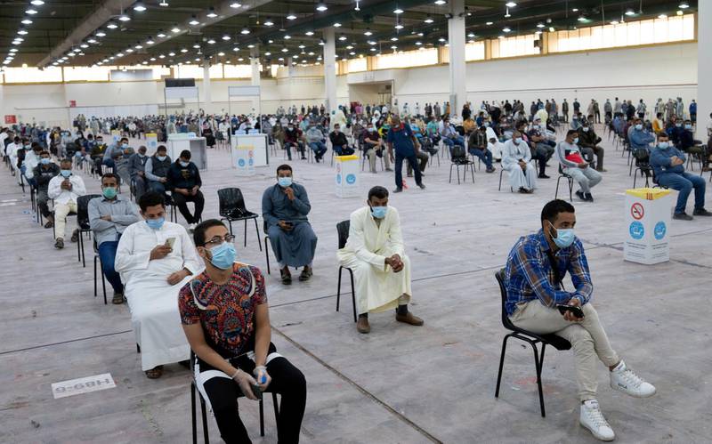 Expatriates wait for mandatory coronavirus testing in a makeshift testing centre in Mishref, Kuwait. REUTERS