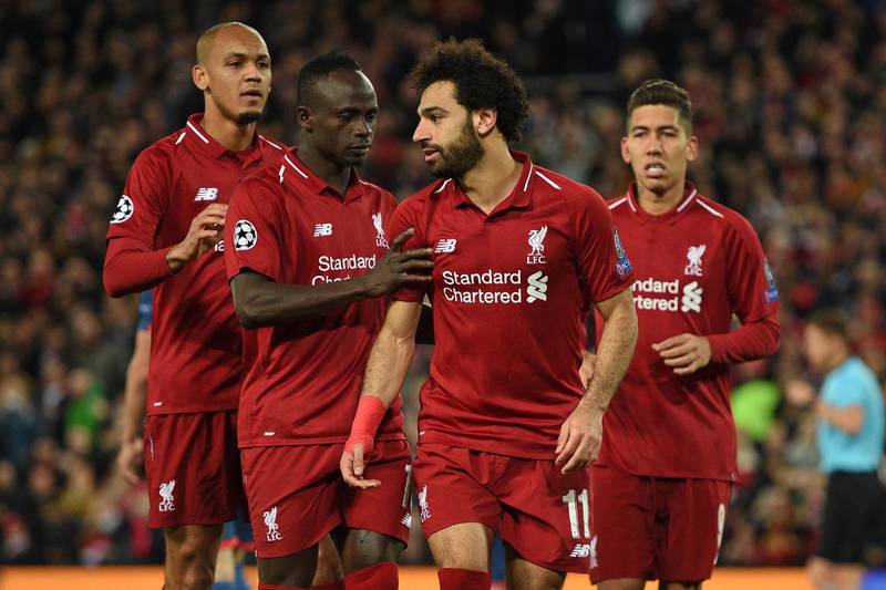 Liverpool's Egyptian midfielder Mohamed Salah (2nd R) celebrates with Liverpool's Senegalese striker Sadio Mane (2nd L) and Liverpool's Brazilian midfielder Fabinho (L) after scoring their third goal from the penalty spot during the UEFA Champions League group C football match between Liverpool and Red Star Belgrade at Anfield in Liverpool, north west England on October 24, 2018.  / AFP / Oli SCARFF                          