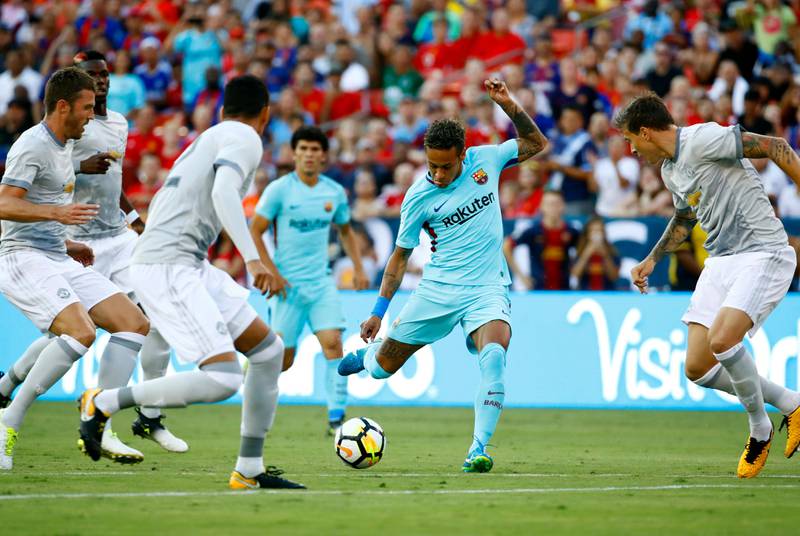 Barcelona's Neymar, centrr, kicks through Manchester United defenders. Patrick Semansky / AFP