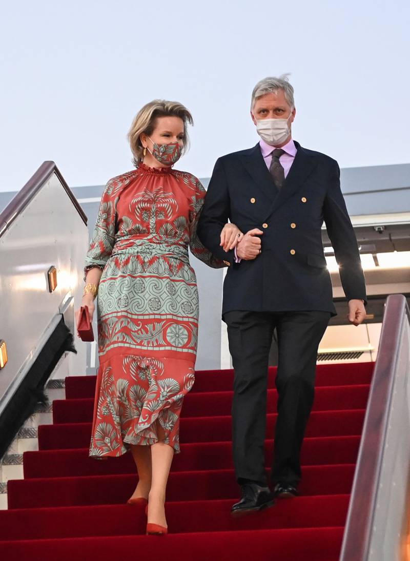 King Philippe and Queen Mathilde of Belgium arrive in Muscat for a three-day visit to Oman. Queen Mathilde wears a Johanna Ortiz burnt orange and mint green palm-print dress with a matching mask. Photo: Oman News Agency