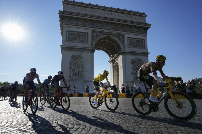 Denmark's Jonas Vingegaard, wearing the overall leader's yellow jersey, passes the Arc de Triomphe during the twenty-first stage of the Tour de France in Paris. AP