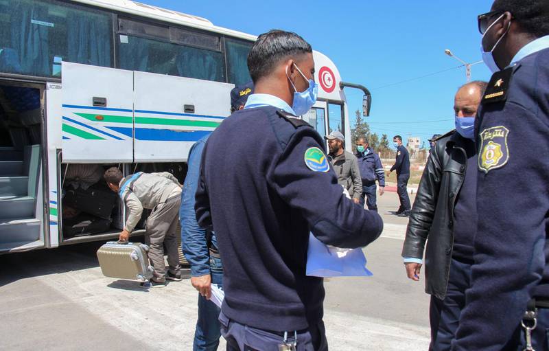 Tunisian border policemen follow up the repatriation of Tunisian workers stranded in Libya as they board buses at the Ras Jedir border post to return to their country. AFP