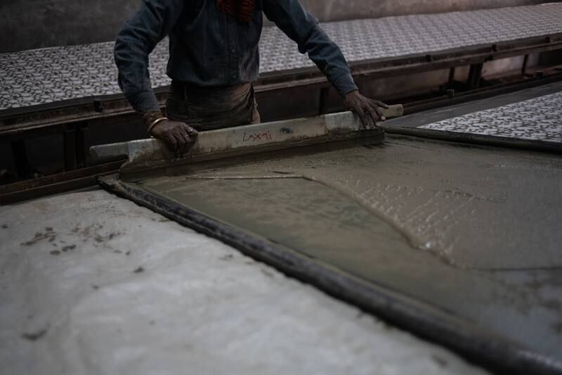 A patterned screen is used to print mud on to fabric. 