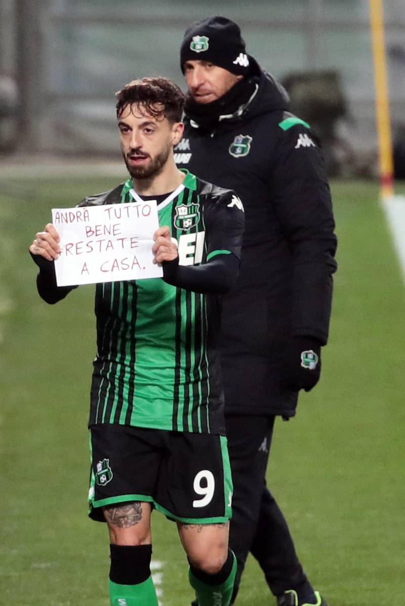 Sassuolo's Francesco Caputo celebrates after scoring, showing a banner reading in Italian 'Everything will be OK. Stay at home' during the Serie A match against Brescia. EPA