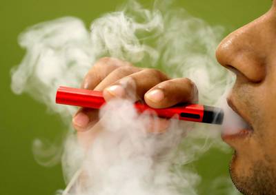 FILE PHOTO: A man uses a vape device in this illustration picture, September 19, 2019. REUTERS/Adnan Abidi/Illustration/File Photo
