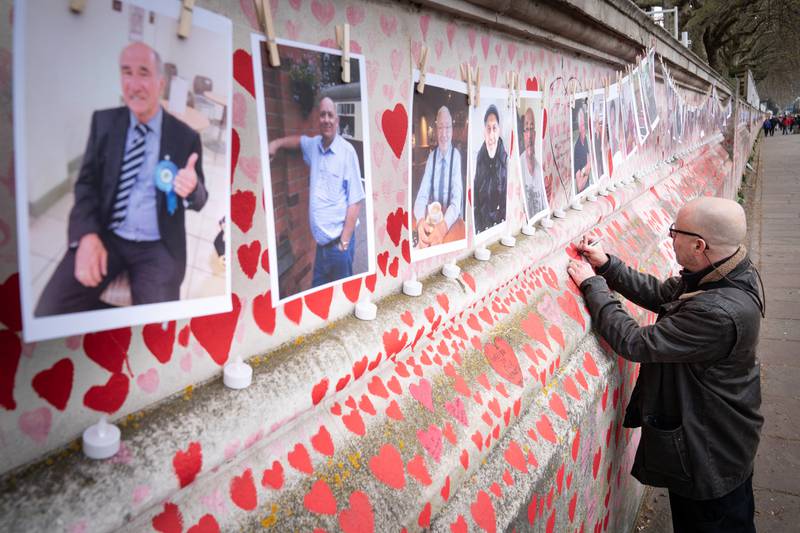 A family member pays their respects to those who lost their lives to Covid-19, as the one year anniversary of the National Covid Memorial Wall is marked in London. PA