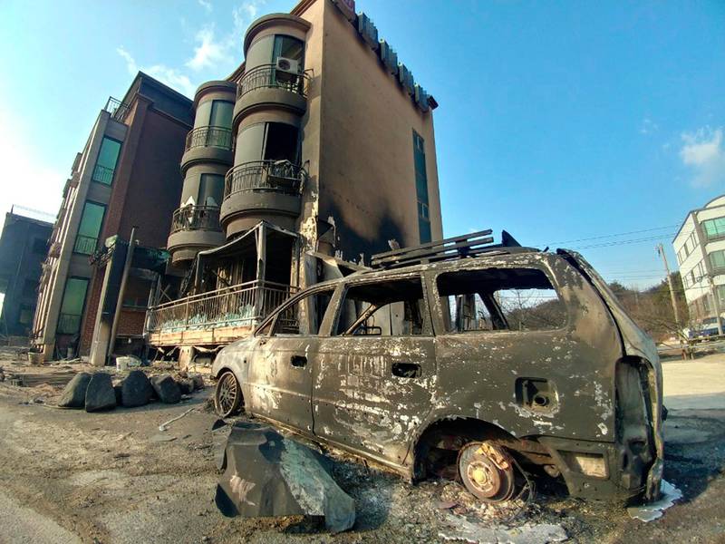 A burnt vehicle sits after being hit by a massive forest fire. Yonhap / AP