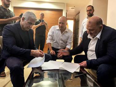 From left, seated, Yesh Atid, leader of Yair Lapid, Yamina party leader Naftali Bennett and Ra'am party leader Mansour Abbas will be part of a disparate coalition. Ra'am via Reuters
