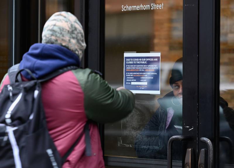 (FILES) In this file photo taken on March 25, 2020, a person points at a sign in front of the closed Department of Labor on March 25, 2020, in New York. US unemployment claims rise 3.3 million for the week of March 21, 2020, according to the US Labor Department on March 26. The Coronavirus outbreak caused highest claims for US jobless benefits on record.
 / AFP / Angela Weiss
