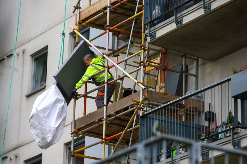 A construction worker inspects cladding at residential apartments in London. Hollie Adams / Bloomberg