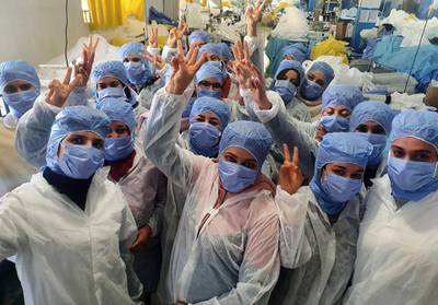 Tunisian women are working on the production of medical masks in a factory in the central city of Kairouan. The factory is able to continue production after 150 workers, seen cheering here, agreed to continue their tasks under confinement. AFP
