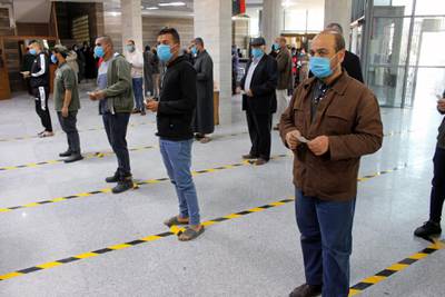 People wear protective masks, as part of precautionary measures against coronavirus disease (COVID-19), as they stand in a queue at a bank in Misrata, Libya March 22, 2020. Picture taken March 22, 2020. REUTERS/Ayman Al-Sahili