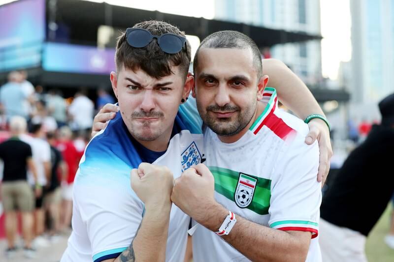 Iran fan Dana Ravanbakhsh (R) with England fan Joe Green. England and Iran fans at the Dubai Media City fanzone for World Cup. Media City, Dubai. Chris Whiteoak / The National
