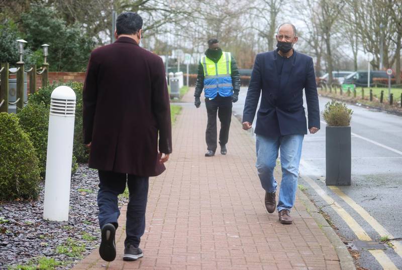 Mohammed Mostafa and Mohamed Noor take their daily exercise, accompanied by a security guard, outside the Holiday Inn, near Heathrow Airport. Reuters