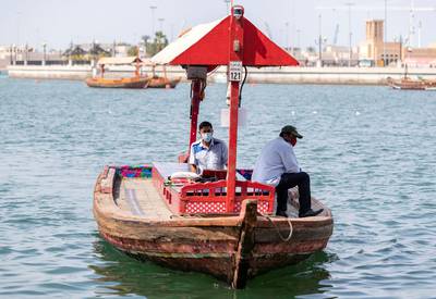 Dubai, United Arab Emirates - Reporter: N/A: Two men on a boat wear face masks on Dubai Creek in response to the corona virus. Thursday, March 26th, 2020. Dubai. Chris Whiteoak / The National