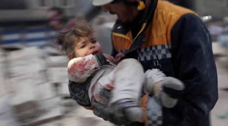 A rescuer carries a Syrian toddler, Raghad Ismail, away from the rubble of a building. Reuters