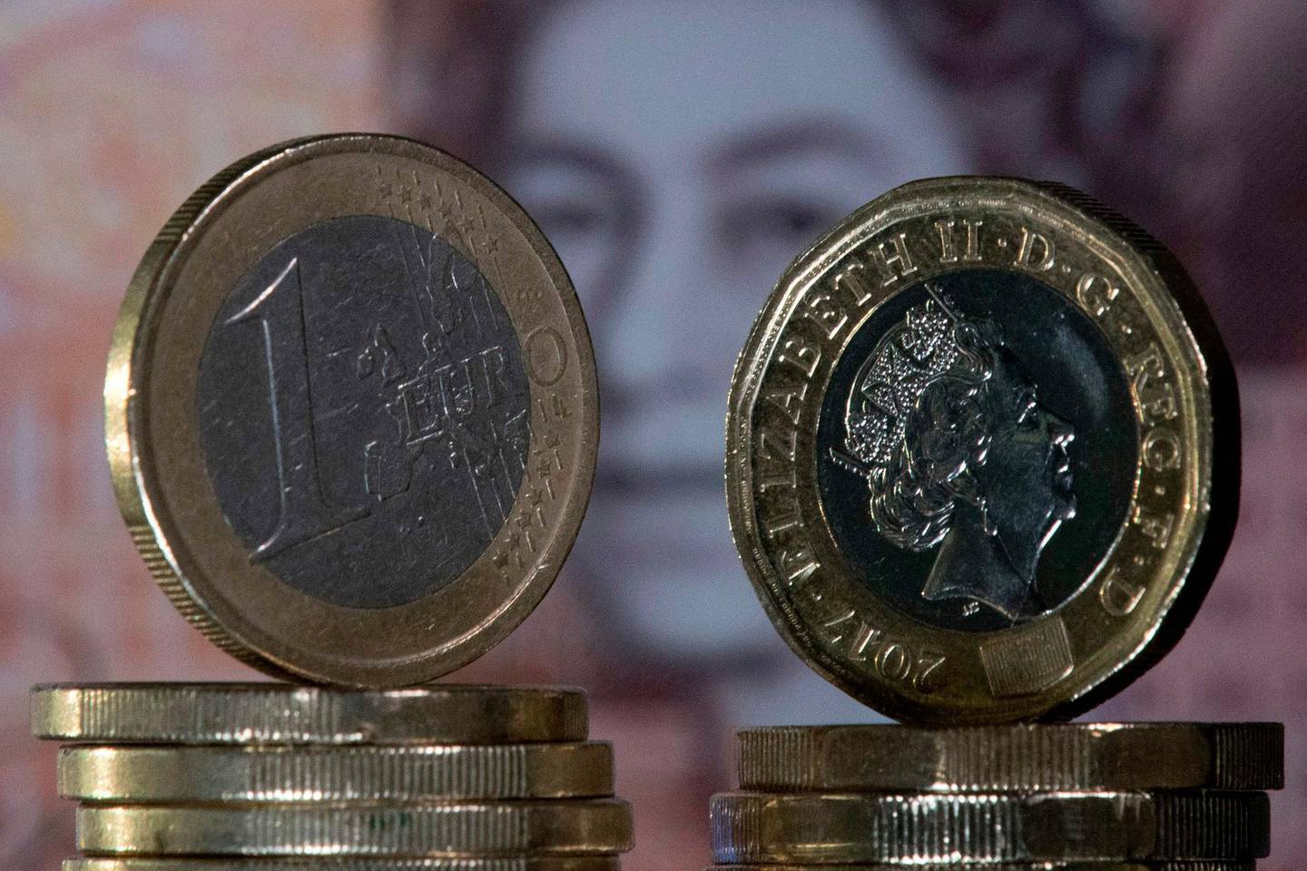 (FILES) In this file photo taken on December 14, 2017, British one pound sterling coins and one Euro coins are arranged in front of a British ten pound sterling note for a photograph in London.  Four and a half years after Britain voted to leave the EU and as eight months of painstaking trade talks reach a climax, Boris Johnson is set on December 13, 2020, to answer the most fundamental question: what is Brexit? Britain left the EU in January and is in a standstill transition period until December 31 while both sides thrash out the terms of their new trading relationship. / AFP / JUSTIN TALLIS
