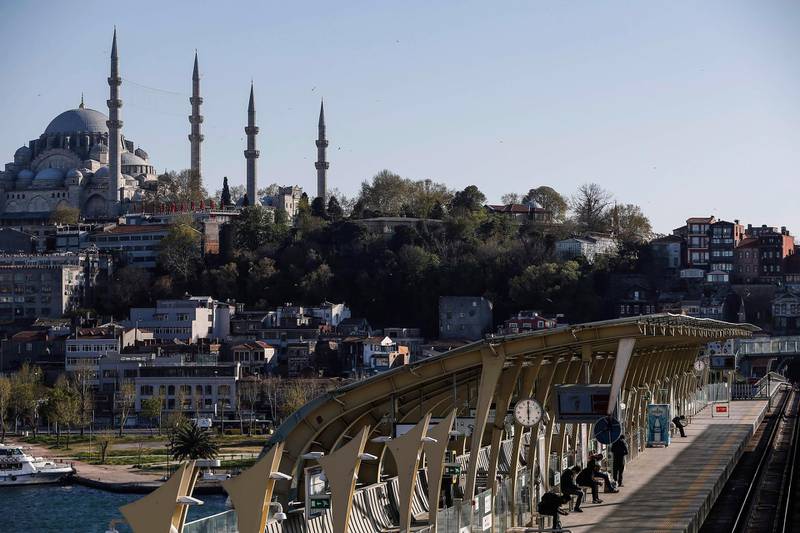 Backdropped by the iconic Suleymaniye Mosque in Istanbul, commuters wait at a metro station on a bridge over the Golden Horn in Istanbul.  AP