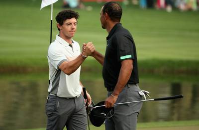 Rory McIlroy, left, and Tiger Woods shake hands on the 18th green on Friday after their second round at the Omega Dubai Desert Classic. Warren Little / Getty Images