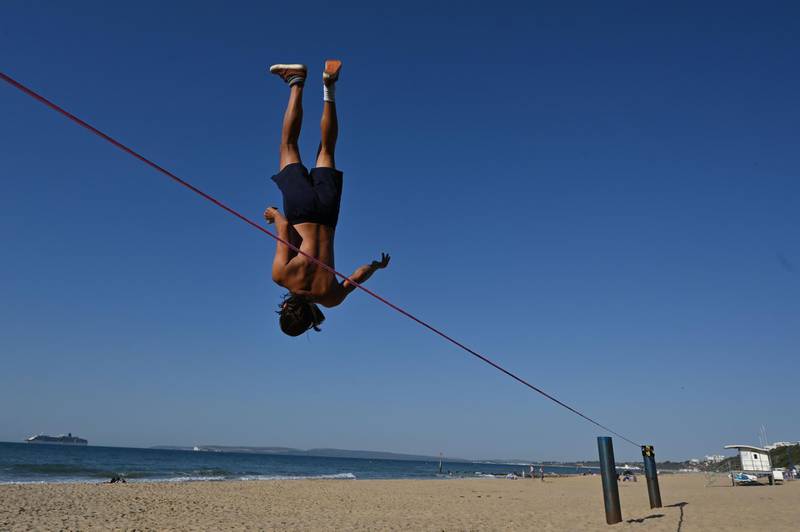 Sandor Nagy practices slacklining at Boscombe Beach in Bournemouth, southern England. AFP