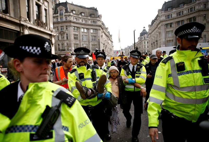 Police officers detain a climate change activist at Oxford Circus during the Extinction Rebellion protest in London, Britain April 17, 2019. REUTERS/Henry Nicholls