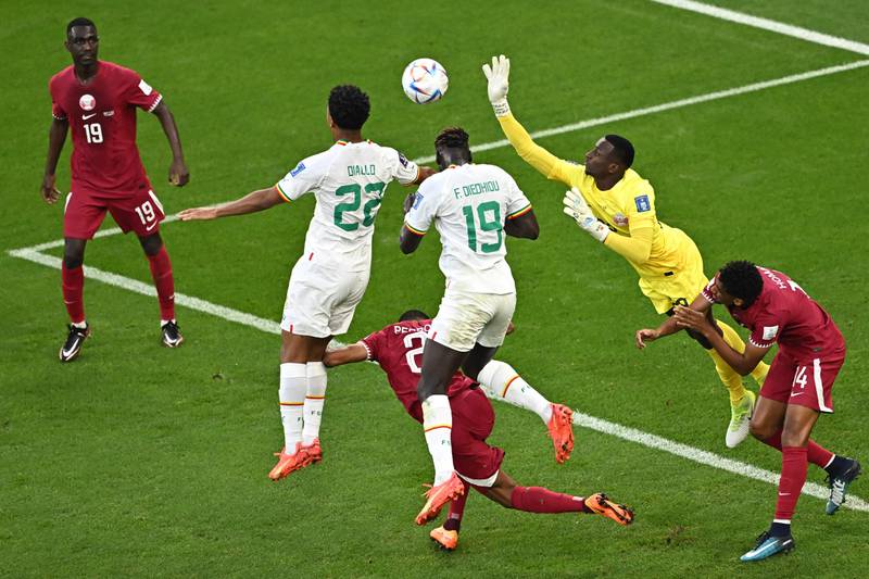 Qatar goalkeeper Meshaal Barsham attempts to clear the ball. AFP