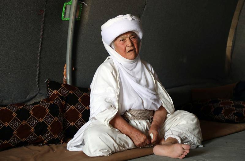 A displaced Iraqi Yazidi woman wearing a traditional outfit, sits inside her tent at a camp for internally displaced people in Khanke, a few kilometres from the Turkish border in Iraq's Dohuk province, on June 24, 2019. AFP