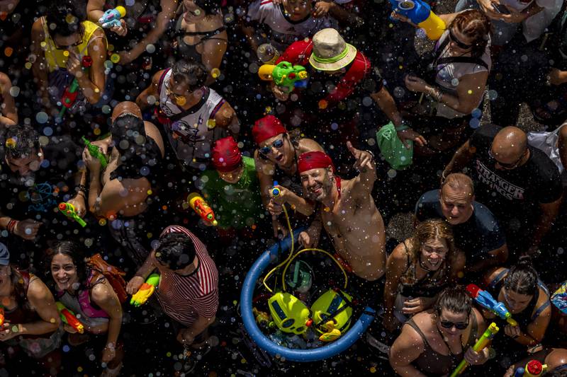 People take part in the annual water fight in the streets of the Vallecas neighbourhood of Madrid. AP