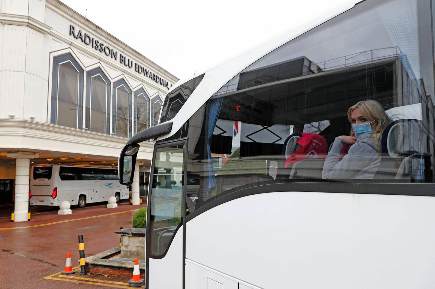 A woman arrives in a coach at the Radisson Blu hotel, where travellers are spending their mandatory hotel quarantine, at Heathrow Airport in west London on February 16, 2021. The mandatory hotel quarantine policy, which began on February 15, 2021, requires all UK citizens and permanent residents returning from 33 countries on its so-called travel ban list to self-isolate in a government approved facility for 10 days. 


 / AFP / Adrian DENNIS
