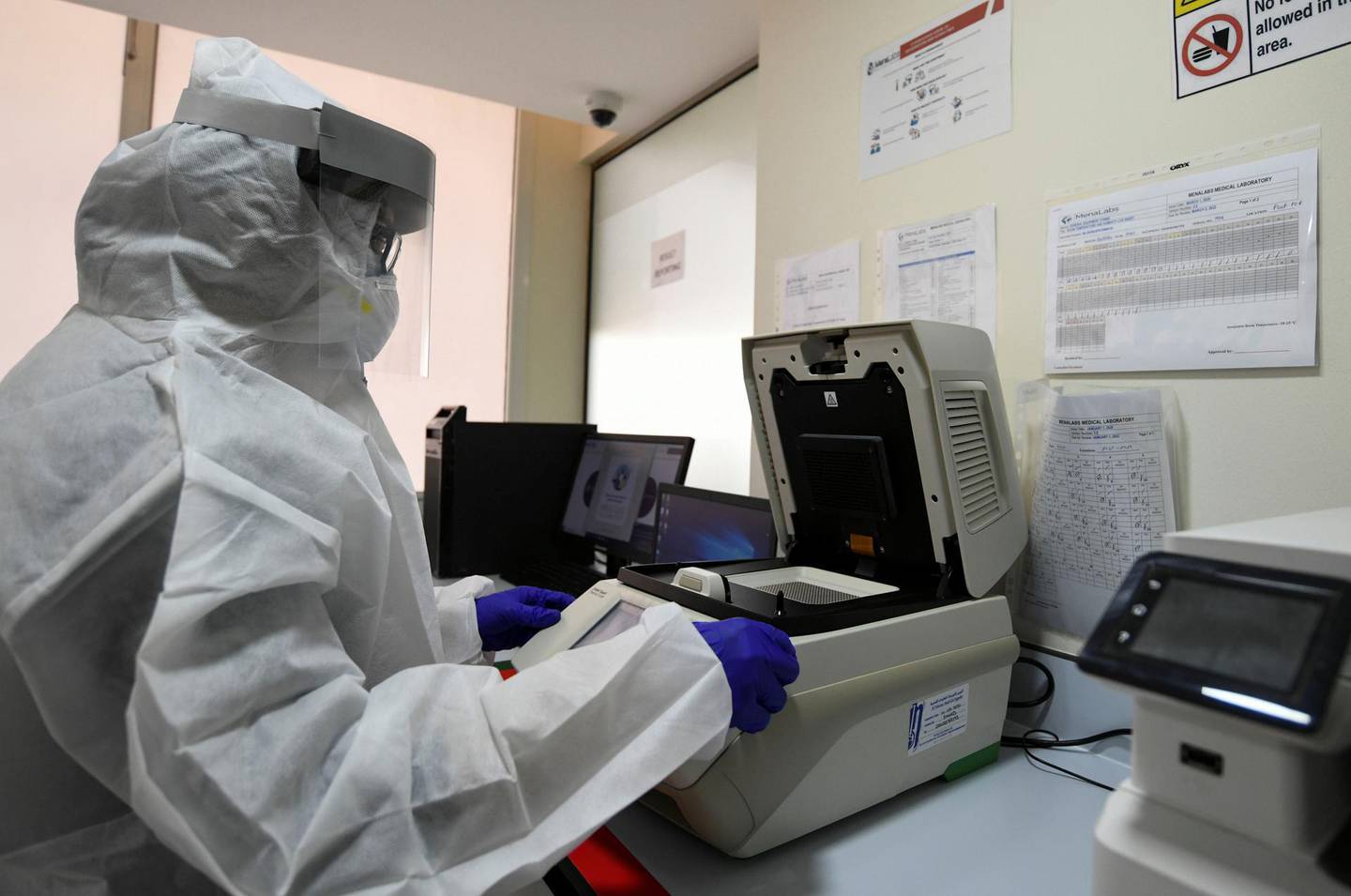 Abu Dhabi, United Arab Emirates - Lab technician wearing a protective suit and face shield carries out PCR testing at MenaLabs Medical Laboratory in Abu Dhabi. Khushnum Bhandari for The National