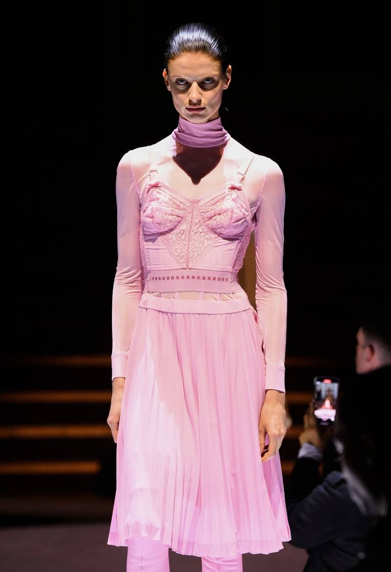 A model walks in a pale pink dress.